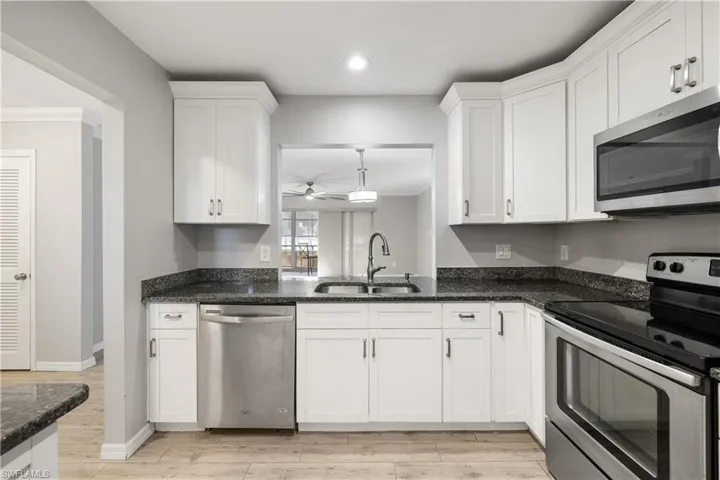 Kitchen featuring white soft-close shaker cabinets, stainless appliances and granite countertops