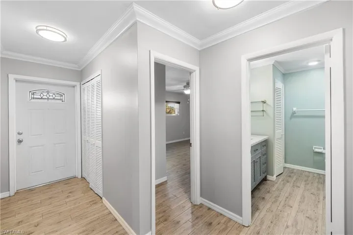 View of the front door to the left, guest room center and guest bathroom right