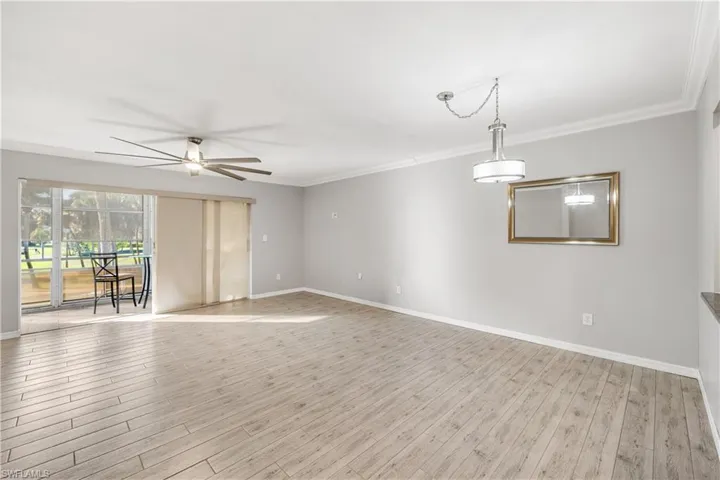 Living room and dining room.  Plank tile flooring throughout and upgraded ceiling fan and dining chandelier