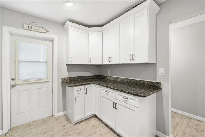 Kitchen featuring white soft-close shaker cabinets and granite countertops