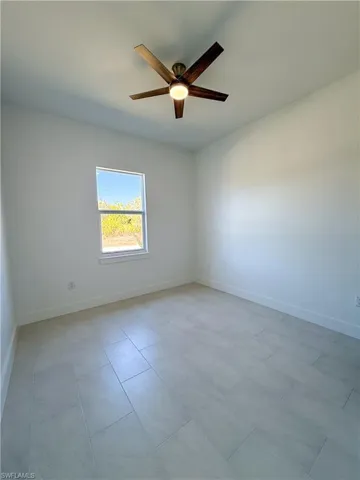 Spare room featuring baseboards and a ceiling fan