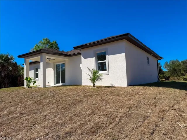 Back of property featuring a yard, stucco siding, and a patio area
