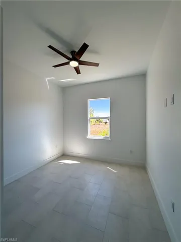 Empty room with baseboards and ceiling fan
