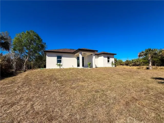 View of front of home featuring stucco siding and a front lawn