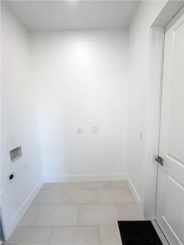 Laundry room featuring hookup for an electric dryer and light tile patterned floors