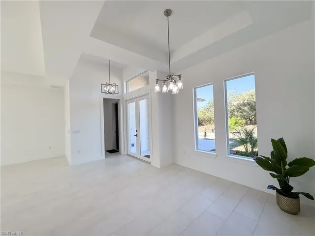 Unfurnished dining area with hanging lights and a tray ceiling