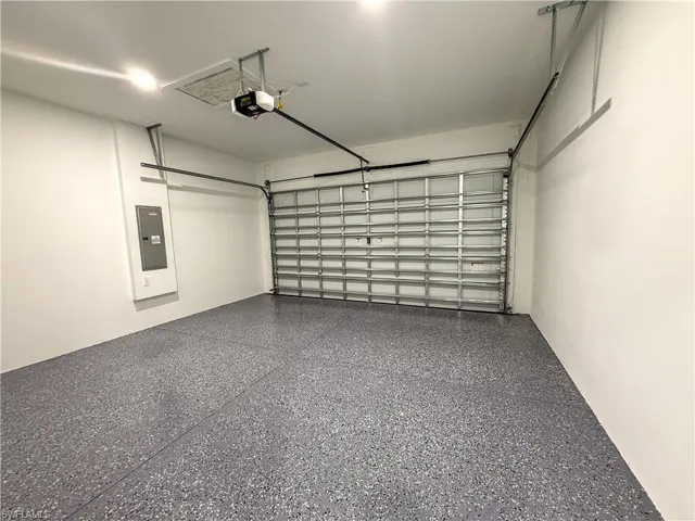 Garage with electric panel and a garage door opener
