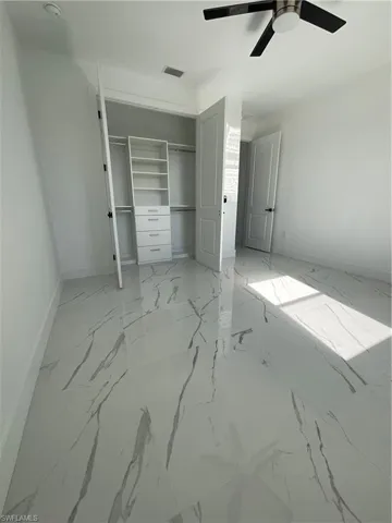 Unfurnished bedroom featuring ceiling fan and a closet