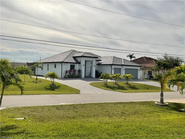 View of front of home featuring a front yard and a garage
