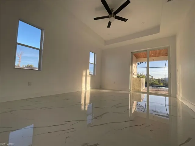 Spare room with ceiling fan and a tray ceiling