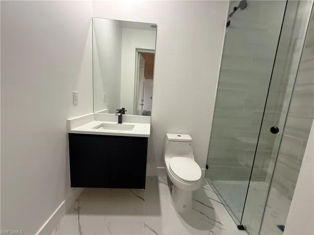 Bathroom with vanity, toilet, and a tile shower