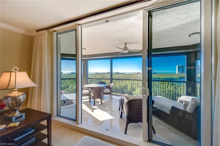 Living room looking out on the enclosed Lanai and Gulf of Mexico in the distance.
