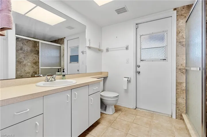 Primary bathroom has a walk in shower and a door to the pool area.