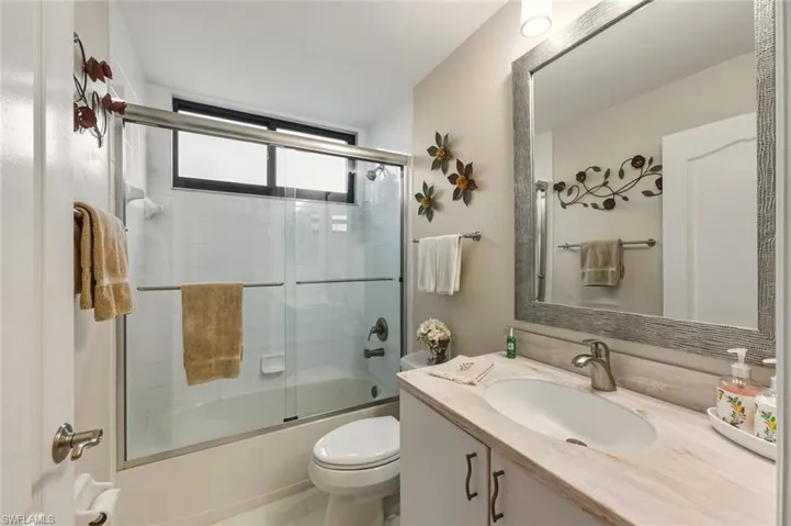 Full bath featuring vanity and combined bath / shower with glass door