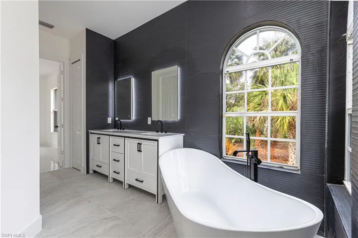 Full bath with double vanity and a freestanding tub