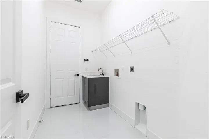 Laundry room with sink, hookup for a washing machine, hookup for an electric dryer