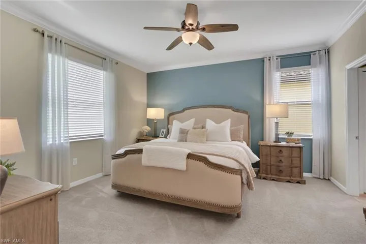 Bedroom featuring crown molding, light colored carpet, and a ceiling fan