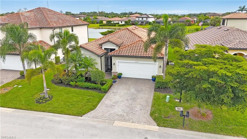 Mediterranean / spanish-style house featuring a residential view, an attached garage, decorative driveway, stucco siding, and a tile roof