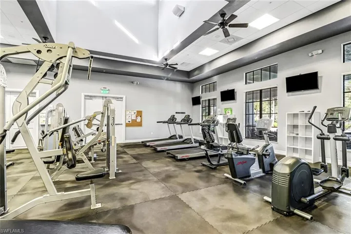 Gym featuring a towering ceiling and a ceiling fan
