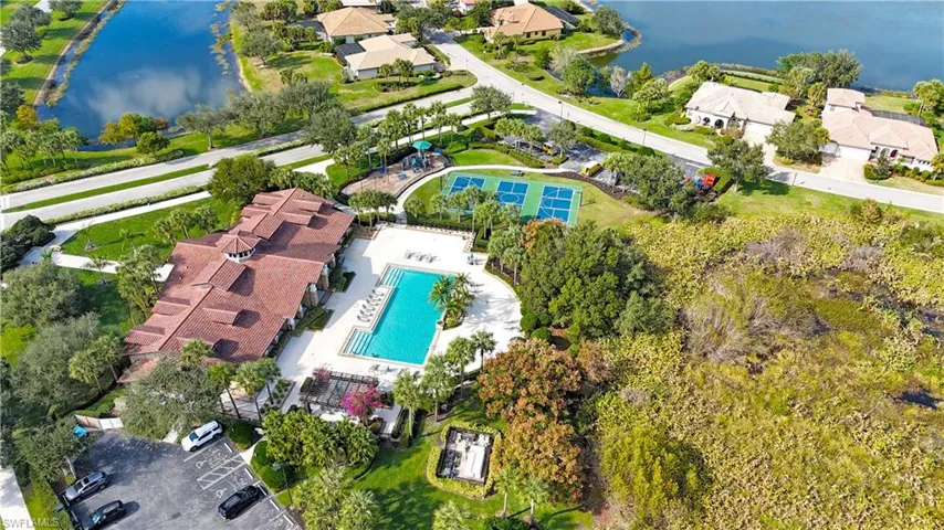 Aerial view of property and surrounding area with a nearby body of water and a pool