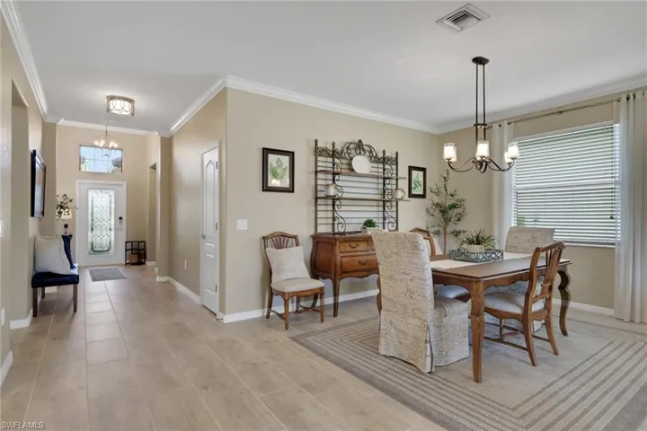 Dining space featuring a chandelier, plenty of natural light, and ornamental molding