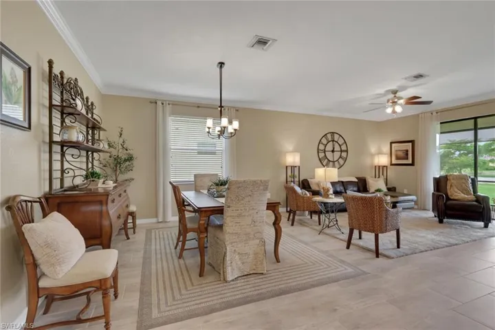 Dining space featuring a ceiling fan, ornamental molding, and a chandelier