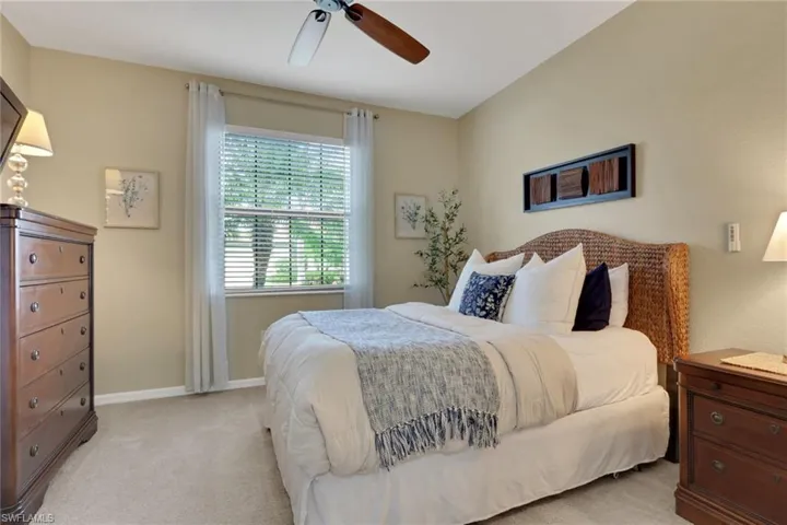 Carpeted bedroom with ceiling fan and baseboards
