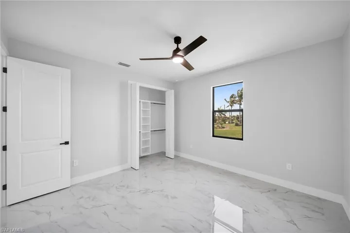 bedroom with a closet, ceiling fan, and light tile floors