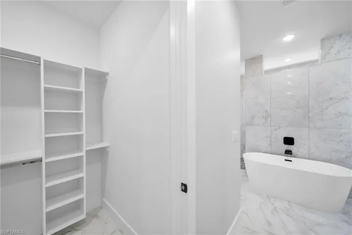 Bathroom with tile walls, tile floors, and a bath to relax in