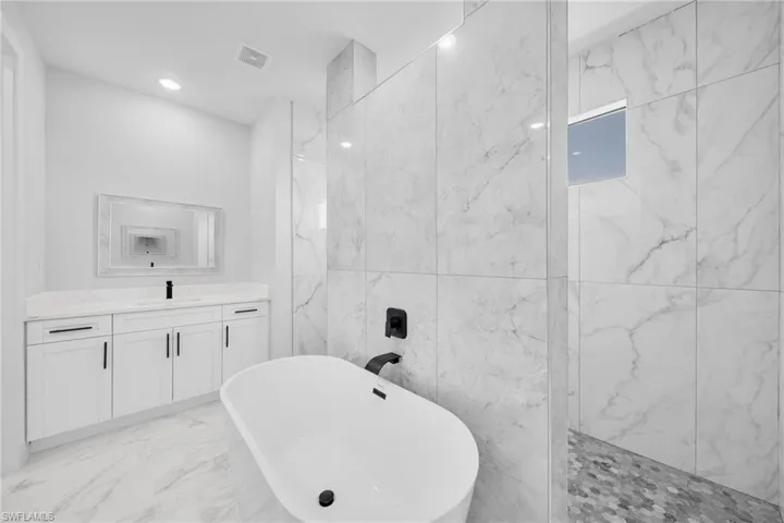 Bathroom featuring tile floors, tile walls, and vanity