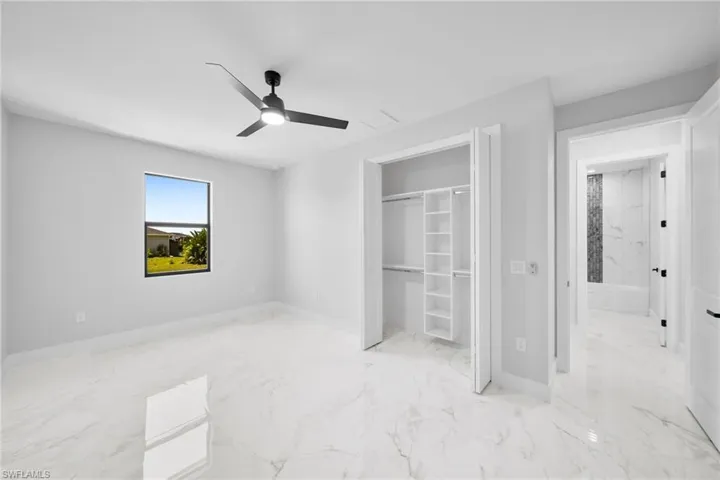 bedroom with a closet, light tile flooring, and ceiling fan