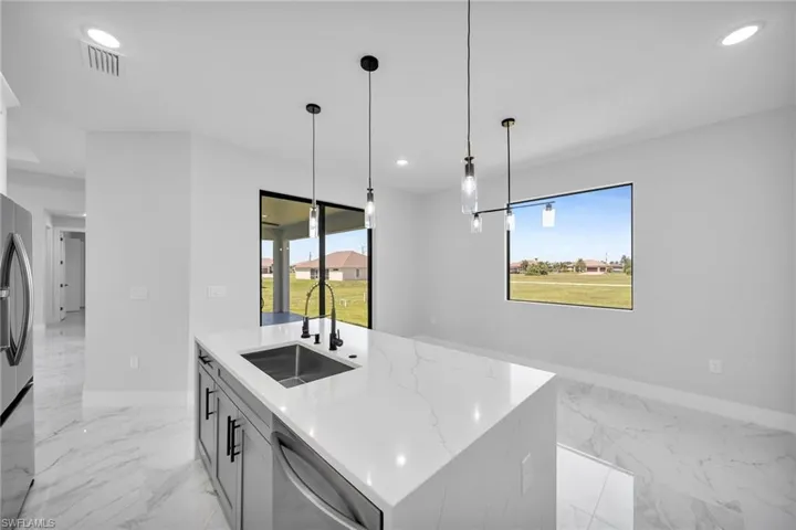 Kitchen featuring sink, a kitchen island with sink, a healthy amount of sunlight, and stainless steel appliances