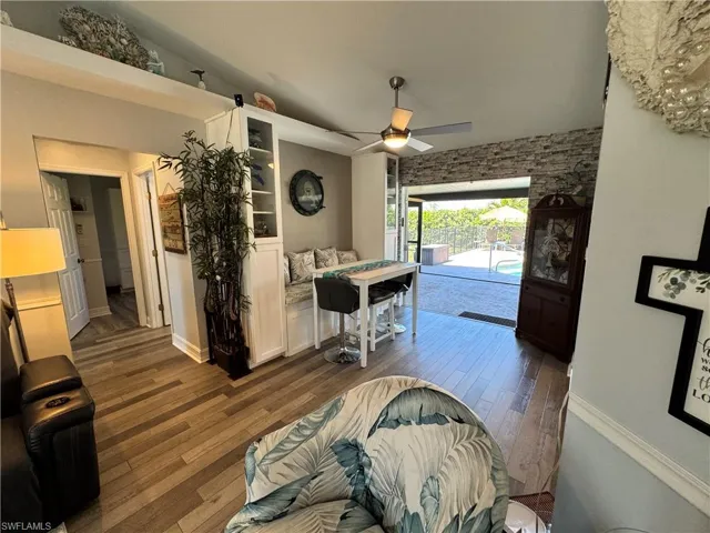 Living area featuring baseboards, ceiling fan, and wood finished floors