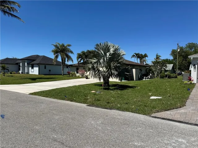 View of front of home featuring concrete driveway and a front lawn