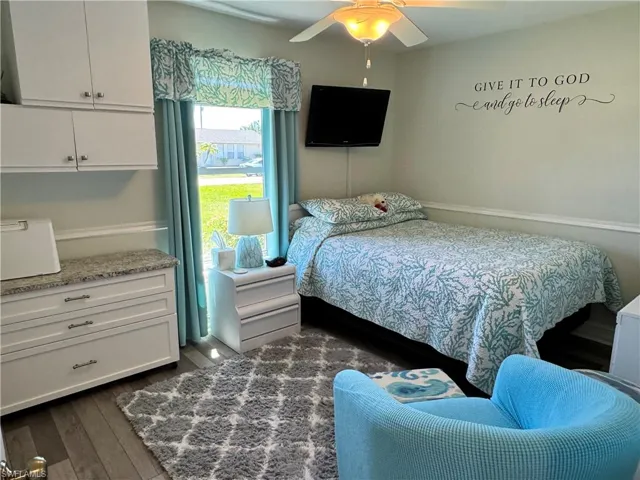 Bedroom with dark wood-style floors and ceiling fan