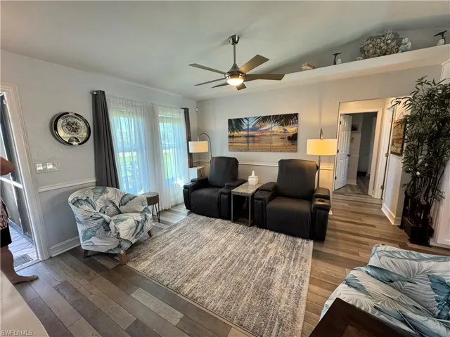 Living room featuring ceiling fan, lofted ceiling, and wood finished floors