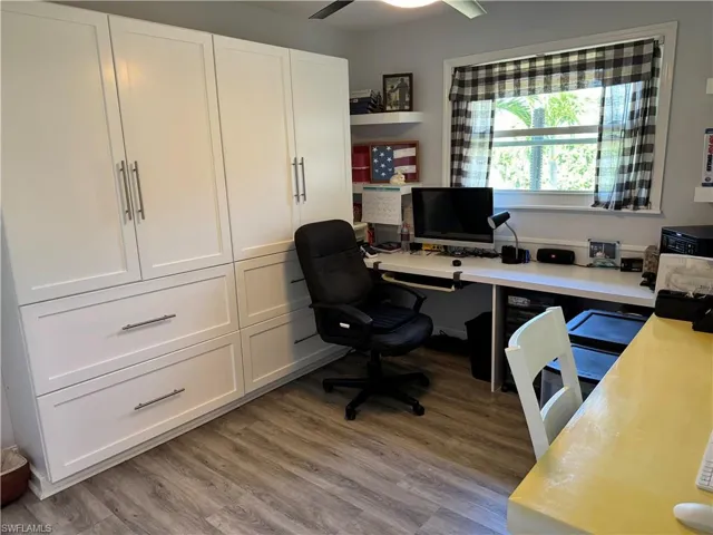 Office with light wood finished floors and a ceiling fan