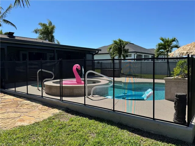 View of pool with a patio, a jacuzzi, fence, and a fenced in pool