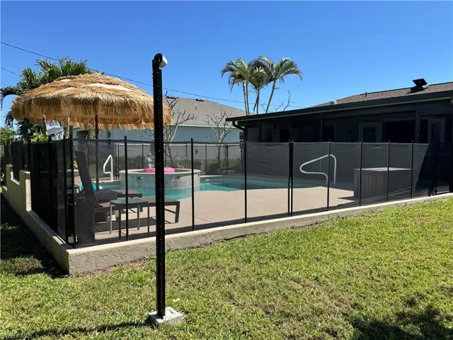 View of swimming pool featuring a patio area, a fenced in pool, a yard, and fence