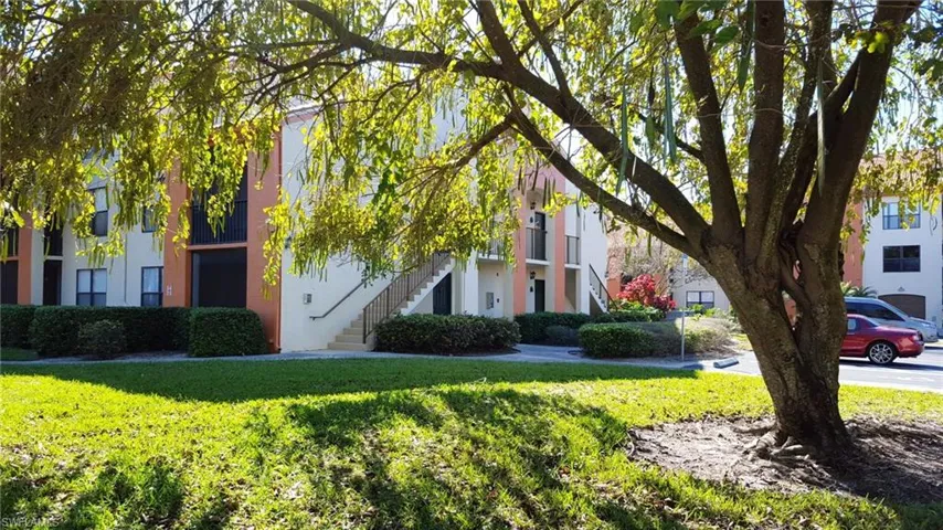 View of building where condo is located.  Open space, big beautiful shade tree.