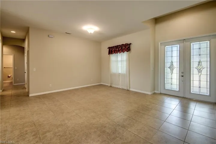 Spare room featuring arched walkways, light tile patterned floors, french doors, and recessed lighting