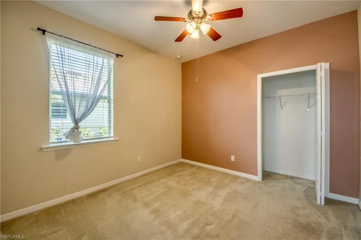 Unfurnished bedroom with carpet, a closet, and ceiling fan