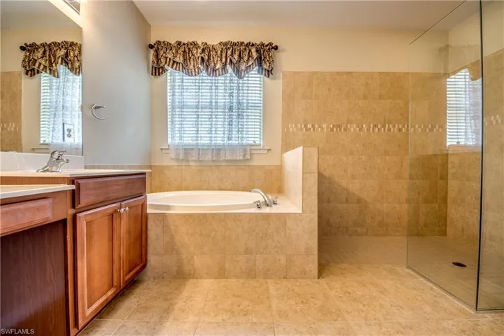 Full bathroom with a garden tub, vanity, plenty of natural light, and walk in shower