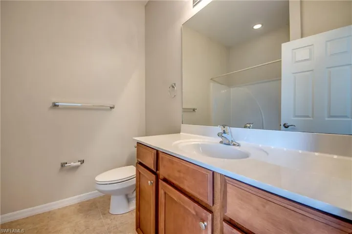 Bathroom with vanity, a shower, and tile patterned floors