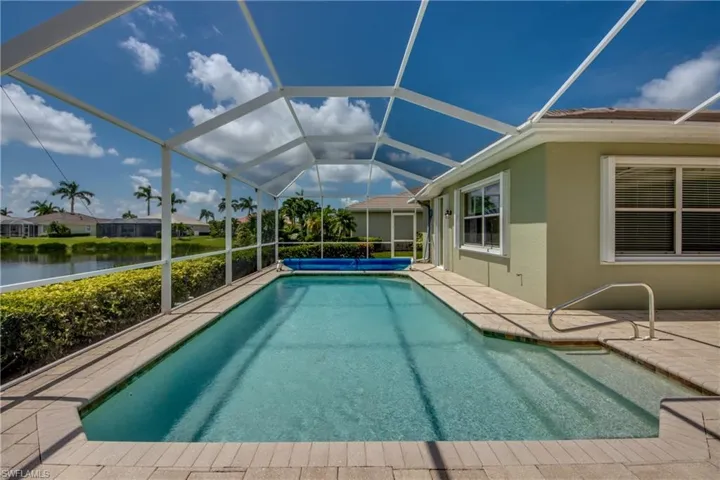 Outdoor pool with a patio area, a water view, and a lanai