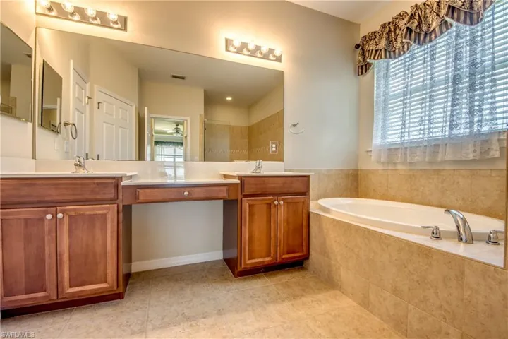 Bathroom with vanity, a bath, tile patterned flooring, and a tile shower