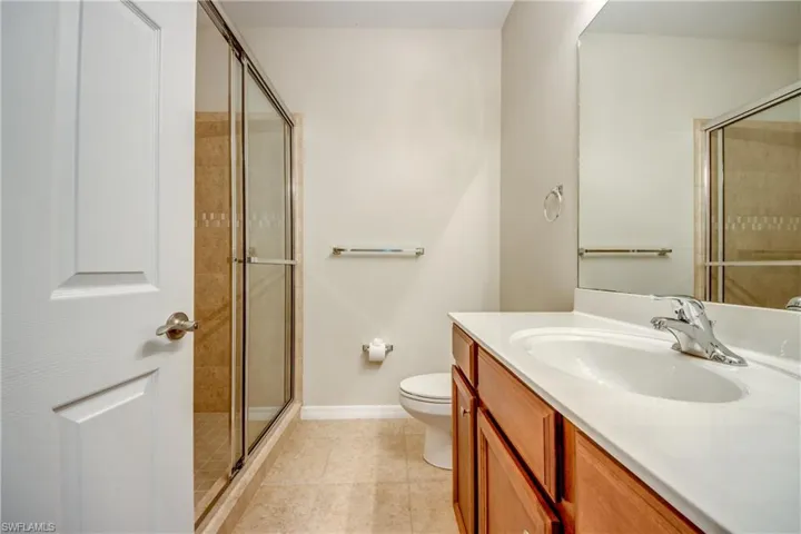 Bathroom featuring vanity, a stall shower, and tile patterned flooring