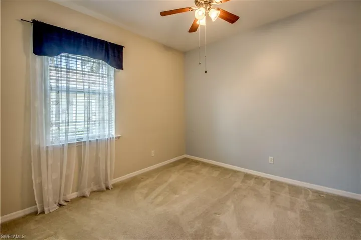 Unfurnished room with healthy amount of natural light, light carpet, and a ceiling fan