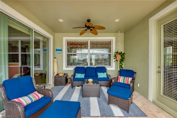 View of patio with an outdoor hangout area and ceiling fan