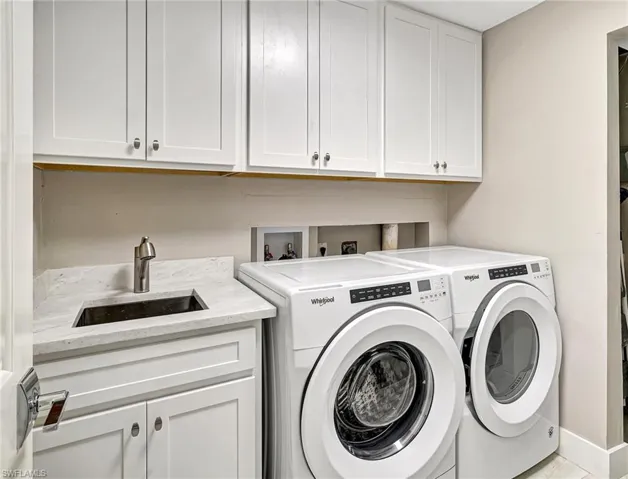 Full size washer and dryer with laundry sink and storage cabinets
